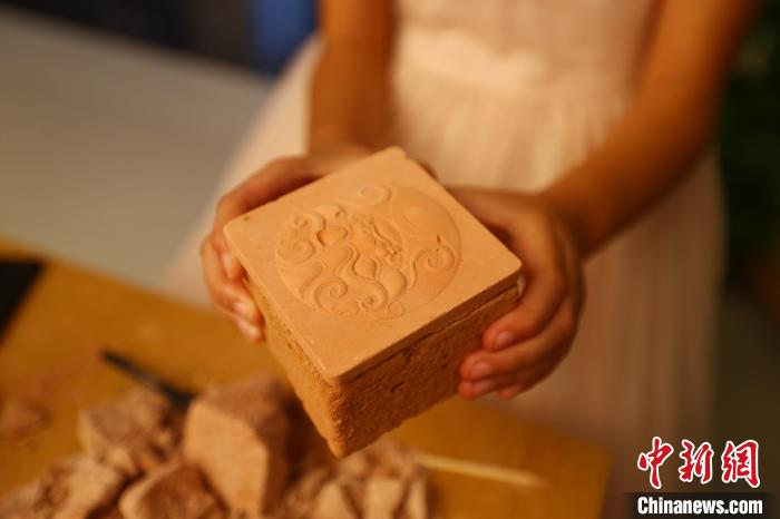 图为江西省博物馆天工坊,一名游客准备打开“考古盲盒”文创产品。 刘占昆 摄 图为江西省博物馆天工坊,一名游客准备打开“考古盲盒”文创产品。 刘占昆 摄