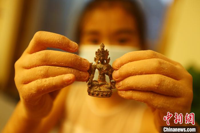 图为一位女孩从“考古盲盒”中挖出的一件“微缩文物”。 刘占昆 摄 图为一位女孩从“考古盲盒”中挖出的一件“微缩文物”。 刘占昆 摄