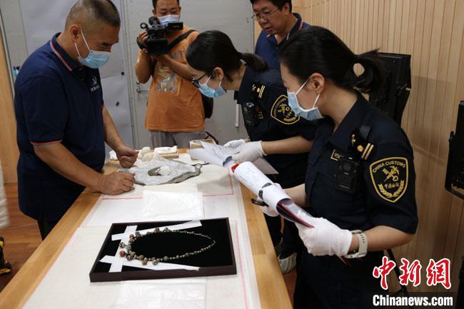 8月5日上午,兰州海关所属敦煌机场海关工作人员对300余件入境参展文物进行通关监管查验。 敦煌机场海关供图